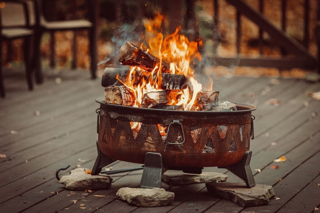 Burning fire pit on timber decking with stoned underneath