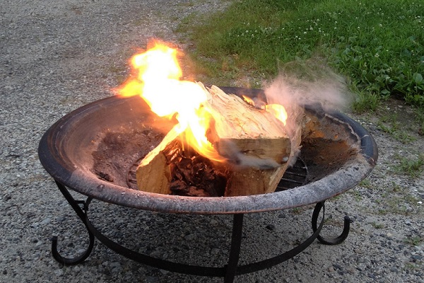 Rusty metal firepit with wood burning