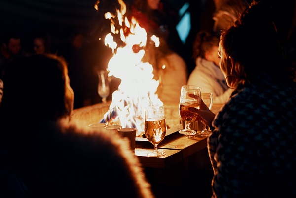 People sitting around a wood fire pit at night