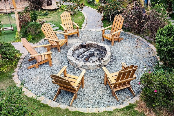 Landscaping around a fire pit and wooden chairs